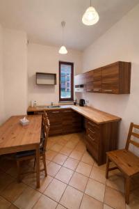 a kitchen with wooden cabinets and a table and a table and chairs at JustInRent Next by Gallery Szpitalna 4D-2 in Legnica