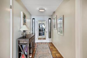 a hallway with a door and a table with a lamp at Beach Club Oasis #304 in Key West