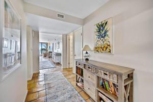 a hallway with a book shelf and a living room at Beach Club Oasis #304 in Key West +32 photos