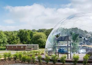 a dome greenhouse in a garden with a house in the background at Rockbridge Country Park in Presteigne