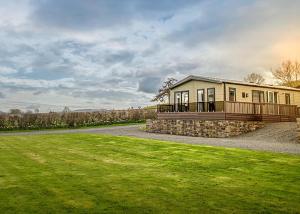 a large house with a porch and a grass field at Rockbridge Country Park in Presteigne +108 photos