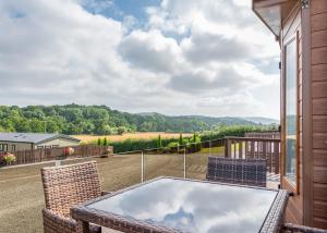 a patio with a table and chairs on a balcony at Rockbridge Country Park in Presteigne