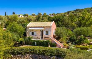 a brick house in the middle of a garden at Amalthia Cottage in Vathi