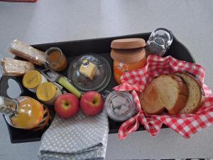 a tray of food with bread apples and other foods at La Source in Angoville +3 photos