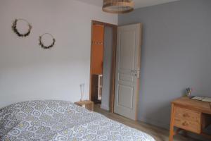 a bedroom with a bed and a dresser and a door at POLIGNY, appartement centre ville in Poligny