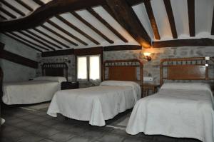 a bedroom with two beds with white sheets at Hotel Rural Verdeancho in Belorado