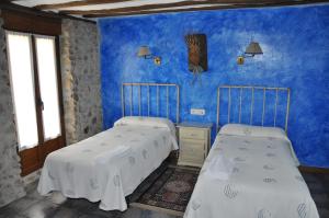 two beds in a room with blue walls at Hotel Rural Verdeancho in Belorado +9 photos
