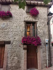 a stone building with flowers on a balcony and a door at Hotel Rural Verdeancho in Belorado