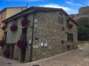 a stone building with flowers on the side of it at Hotel Rural Verdeancho in Belorado