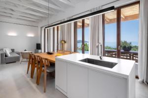 a kitchen with a wooden table and a large window at Villa Anthilia in Syvota