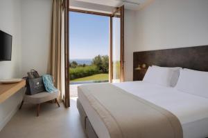 a bedroom with a bed and a desk and a window at Villa Anthilia in Syvota +14 photos