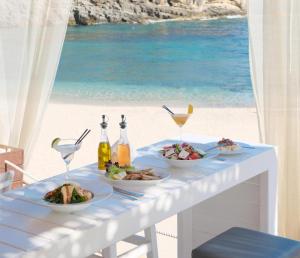 a table with plates of food and a view of the beach at Villa Anthilia in Syvota