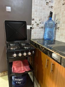 a kitchen with a stove and a bottle of water at Twendzetu kilifi in Kilifi