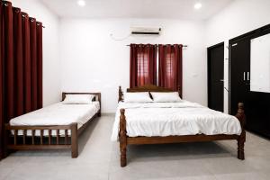two beds in a room with red curtains at Varkala Days Home Stay in Varkala