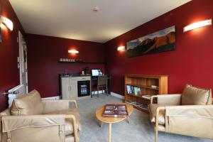a living room with red walls and couches and a table at Silverstone Lodge in National Park