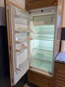an empty refrigerator with its door open in a kitchen at Pension Heller in Odelzhausen