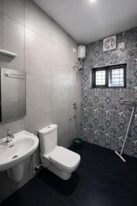 a bathroom with a white toilet and a sink at Varkala Days Home Stay in Varkala +38 photos