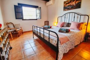 a bedroom with a bed and a chair in a room at Gusta la Vista in Ríogordo +52 photos