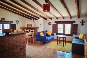 a living room with blue couches and a table at Gusta la Vista in Ríogordo