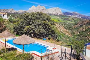 a villa with a swimming pool with mountains in the background at Gusta la Vista in Ríogordo