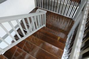a staircase with wood flooring and white railings at A Plus Deluxe Hotel in Ko Lipe