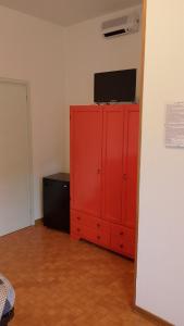 a red cabinet with a television on top of it at Locanda da Lucia in Noventa di Piave