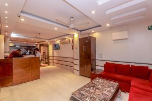a living room with a red couch and a counter at Avtar new delhi railway station in New Delhi