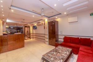 a living room with a red couch and a kitchen at Avtar new delhi railway station in New Delhi