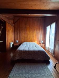a bedroom with a large bed in a wooden wall at Maison familiale Pays Basque in Ahaxe-Alciette-Bascassan