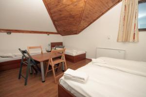 a room with two beds and a table and chairs at Yan BibiYan Guest House in Negushevo