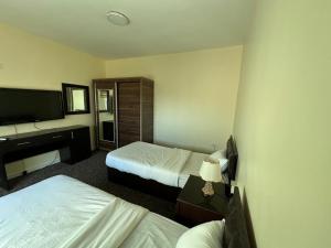 a hotel room with two beds and a television at Sultan Palace Apartments in Wadi Musa