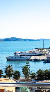 a cruise ship docked in a harbor with palm trees at New Beach Suite in Sarandë +115 photos