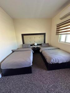 a bedroom with two beds in a room at Sultan Palace Apartments in Wadi Musa +4 photos
