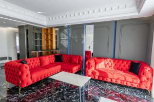 two red couches and a table in a room at New Beach Suite in Sarandë