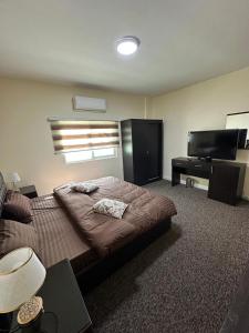 a bedroom with a bed and a flat screen tv at Sultan Palace Apartments in Wadi Musa