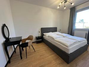 a bedroom with a bed and a desk and a chair at Apartament w centrum 5A in Iława