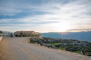 a building on top of a mountain with the sun setting at Hotel Sokoline in Danilovgrad