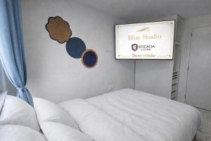 a bedroom with a bed and a sign on the wall at Blue Studio - Cozinha Privativa - Eficacia Living Abrantes in Abrantes