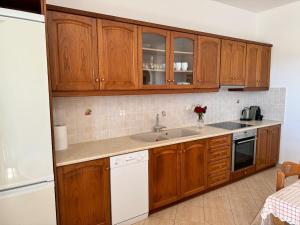 a kitchen with wooden cabinets and a sink at Limnes Seaside Retreat in Naxos Chora