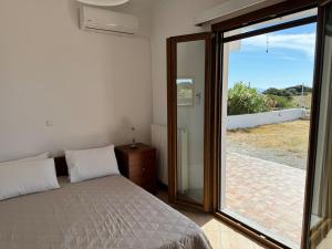 a bedroom with a bed and a sliding glass door at Limnes Seaside Retreat in Naxos Chora