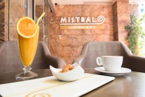 a glass of orange juice and a bowl of nuts and a cup of coffee at Mistral Hotel in Paralia Katerinis