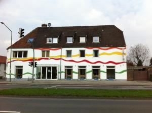 ein weißes Gebäude mit einer roten gelben und grünen Fassade in der Unterkunft Hotel Appart in Osnabrück