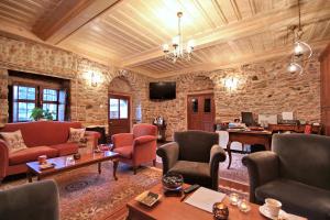 a room with chairs and tables and a stone wall at Archontiko in Andritsaina