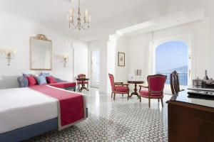 a hotel room with a bed and a table and chairs at Grand Hotel Ambasciatori in Sorrento