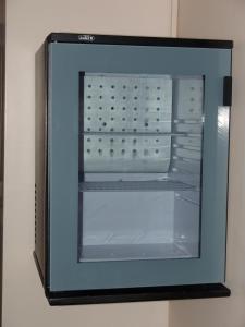 an empty refrigerator with its door open on a wall at Hotel Cosmos in Athens