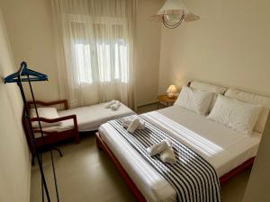 a bedroom with two beds and a chair in it at Mary's Villa in Xanthi +26 photos