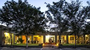 a building with trees in front of it at Hadassa Guest House in Otjiwarongo