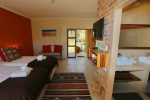 a hotel room with two beds and a sink at Hadassa Guest House in Otjiwarongo