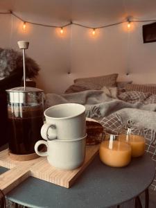 a table with two coffee cups and candles on a bed at Torshaug glamping in Trondheim