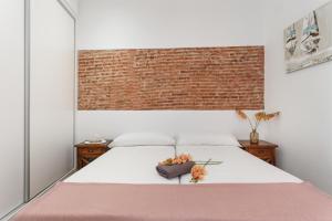 1 dormitorio con 1 cama con pared de ladrillo en Matarolux 7 en Mataró